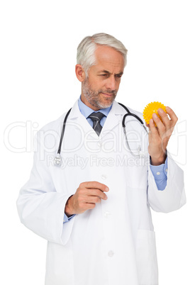 Concentrated male doctor looking at stress ball