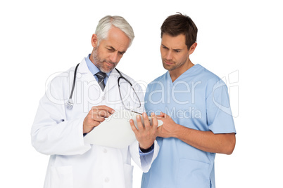 Male doctor and surgeon looking at reports