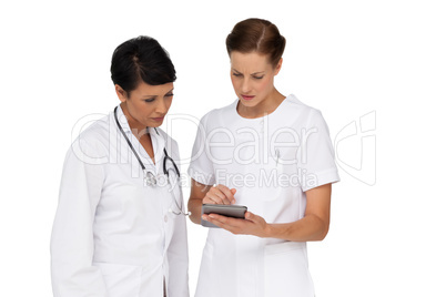 Two female doctors using digital tablet