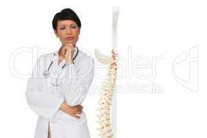 Thoughtful female doctor with skeleton model
