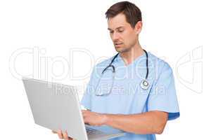 Concentrated male surgeon using laptop