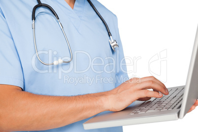 Close-up mid section of a male surgeon using laptop