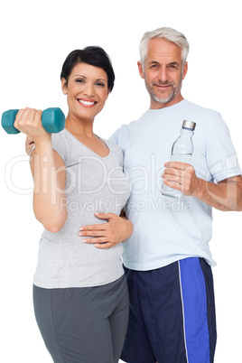 Happy fit couple with dumbbell and water bottle