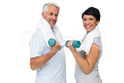 Fit mature couple exercising with dumbbells