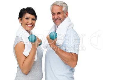 Fit mature couple exercising with dumbbells