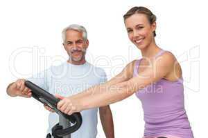 Portrait of a happy woman on stationary bike with trainer