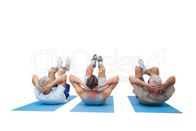 Full length of three men doing abdominal crunches