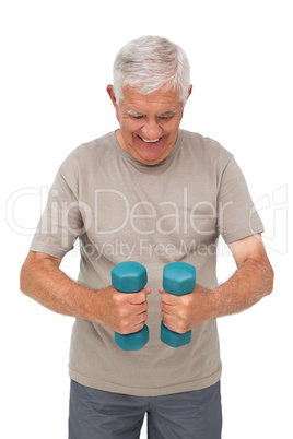 Portrait of a happy senior man exercising with dumbbells