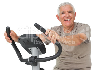Portrait of a happy senior man on stationary bike
