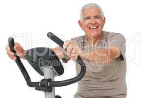 Portrait of a happy senior man on stationary bike