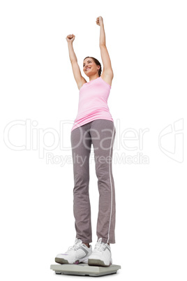Young woman cheering on weight scale
