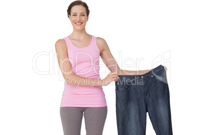 Portrait of a beautiful fit woman holding an old jeans