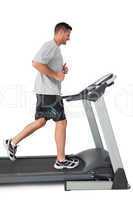 Full length of a young man running on a treadmill