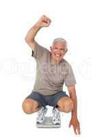 Senior man cheering on weight scale
