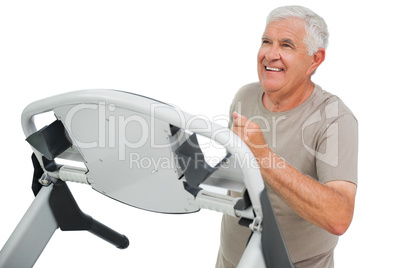 Happy senior man running on a treadmill