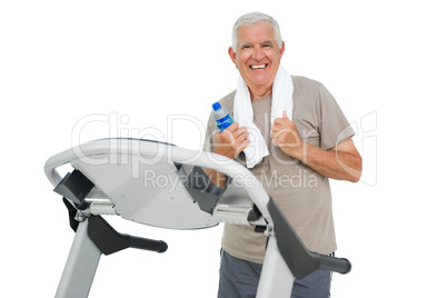 Happy senior man running on a treadmill