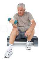 Full length of a senior man exercising with dumbbell