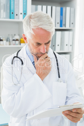 Concentrated male doctor looking at reports