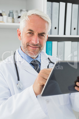 Male doctor using digital tablet at medical office