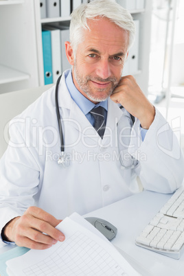 Mature male doctor at desk in the medical office