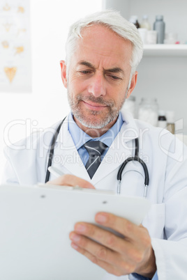 Concentrated male doctor writing reports