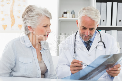 Male doctor explaining x-ray report to senior patient