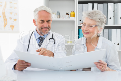 Doctor with female patient reading reports