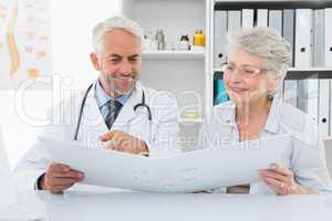 Doctor with female patient reading reports
