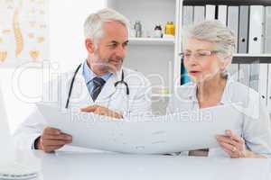 Doctor with patient reading reports at medical office