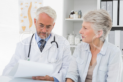 Doctor with female patient reading reports