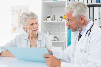 Male doctor with female patient reading reports