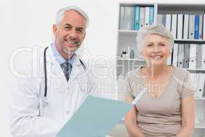 Portrait of a doctor and senior patient with reports