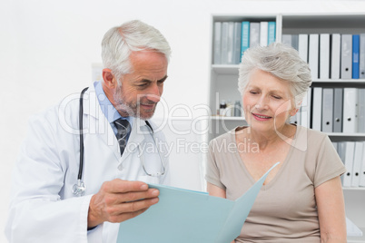 Male doctor and senior patient with reports