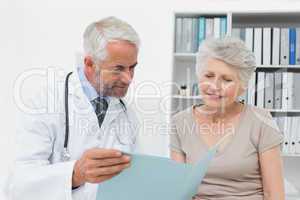 Male doctor and senior patient with reports