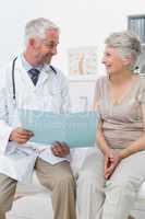 Male doctor and senior patient with reports