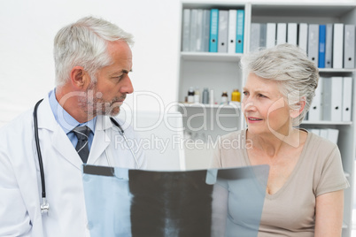 Male doctor explaining x-ray to senior patient