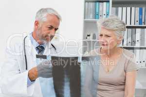Male doctor explaining x-ray to senior patient