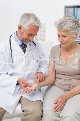 Male doctor taking a senior females pulse