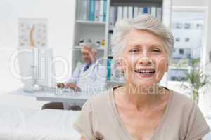 Happy senior patient with doctor at medical office