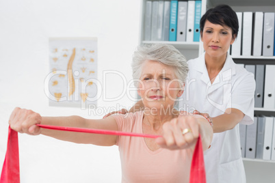 Physiotherapist massaging senior womans back