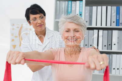 Female physiotherapist massaging senior womans back