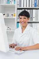 Confident smiling female doctor using computer