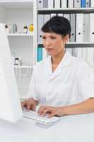 Concentrated female doctor using computer