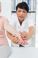 Physiotherapist examining a senior patients hand