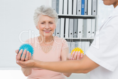 Doctor with senior patient using stress buster balls