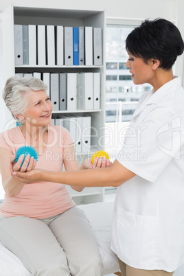 Doctor with senior patient using stress buster balls