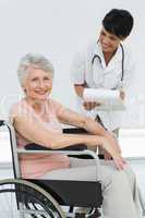 Female doctor talking to a senior patient in wheelchair