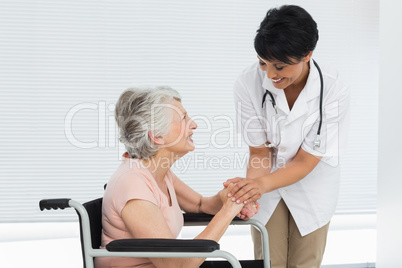 Female doctor talking to a senior patient in wheelchair