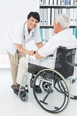 Female doctor talking to senior patient in wheelchair