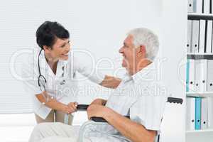 Female doctor talking to senior patient in wheelchair